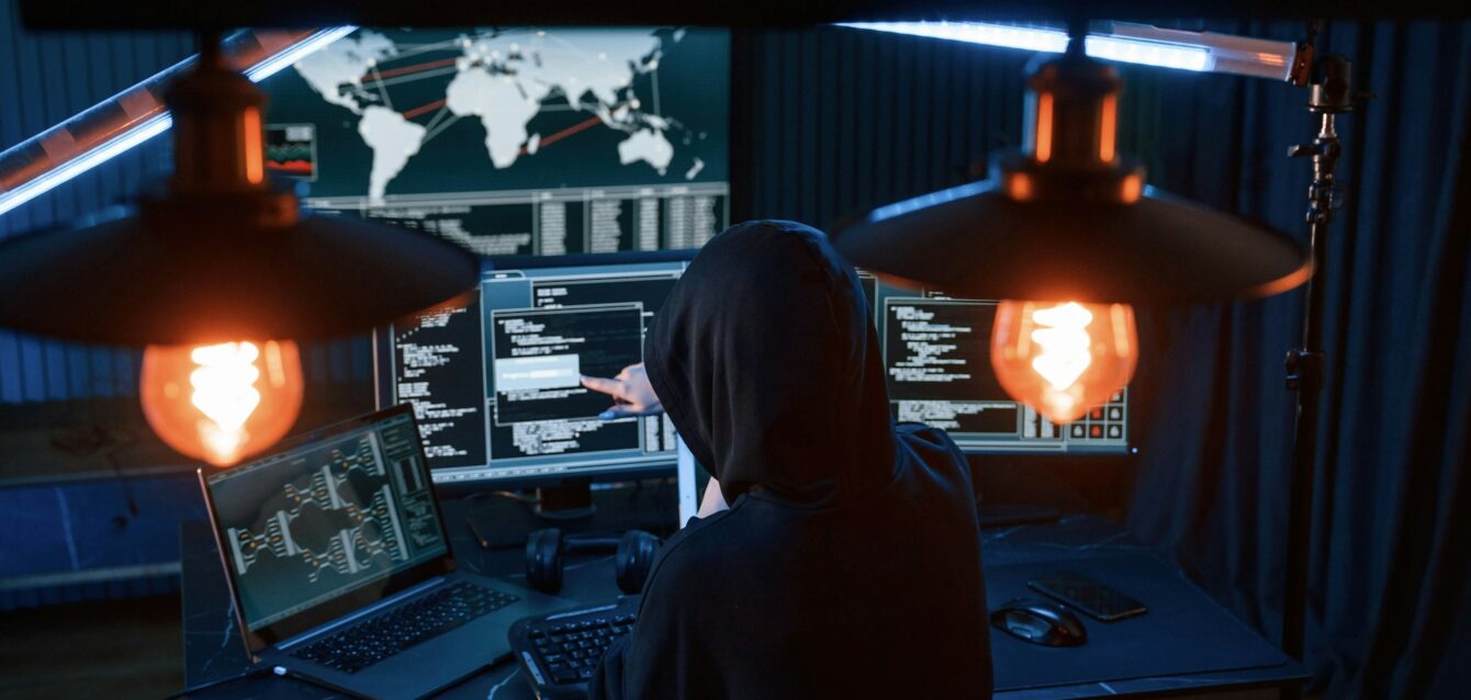 young-professional-female-hacker-is-indoors-by-computer-with-lot-of-information-on-displays